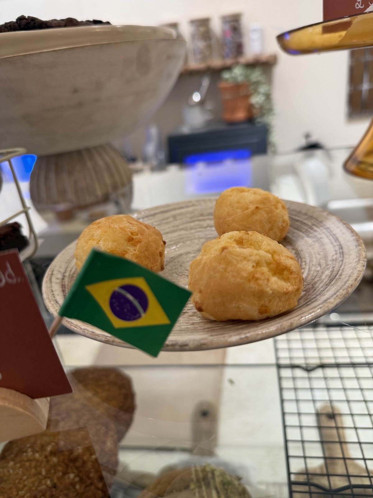 A plate of Brazilian cheese breads with a small flag pick